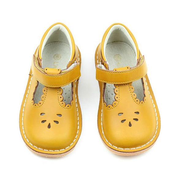 Angie is a vintage inspired shoe in the loveliest golden hue. The scalloped detail just sweetens up every outfit. For those of you whose little one is outgrowing the Dottie, fret not because Angie is an extension of the darling style! This mustard leather offers a unique patina and a sturdiness that can withstand the greatest adventures. Note: for an added touch, pair with our socks.